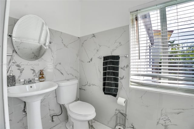 bathroom featuring toilet and tile walls