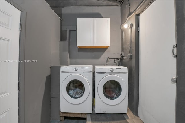 washroom featuring cabinets and independent washer and dryer