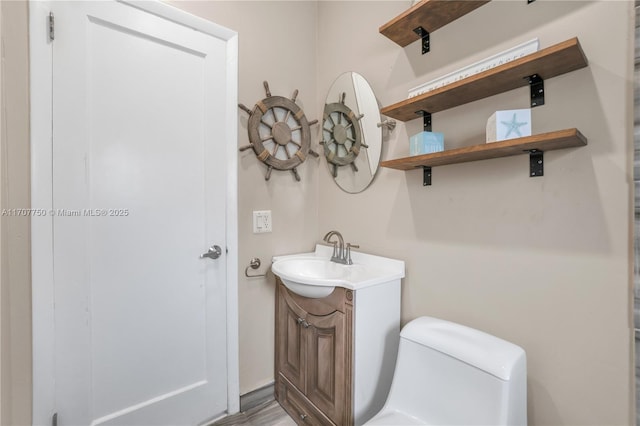 bathroom with wood-type flooring, vanity, and toilet