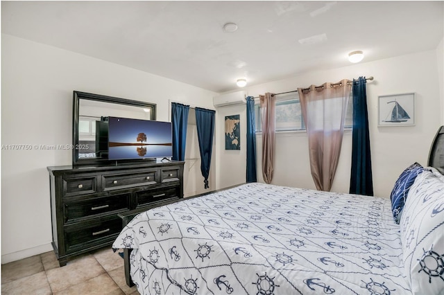 bedroom featuring a wall unit AC and light tile patterned floors