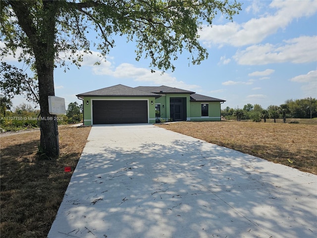 view of front of home with stucco siding, an attached garage, and driveway