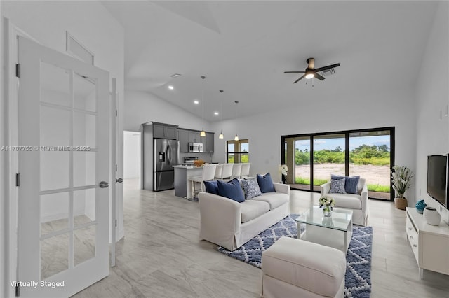 living room with ceiling fan, high vaulted ceiling, and plenty of natural light