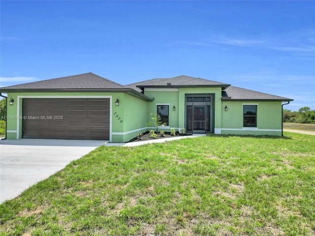 view of front of house featuring a front yard, stucco siding, an attached garage, and driveway