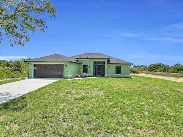single story home featuring driveway, a front yard, a garage, and stucco siding