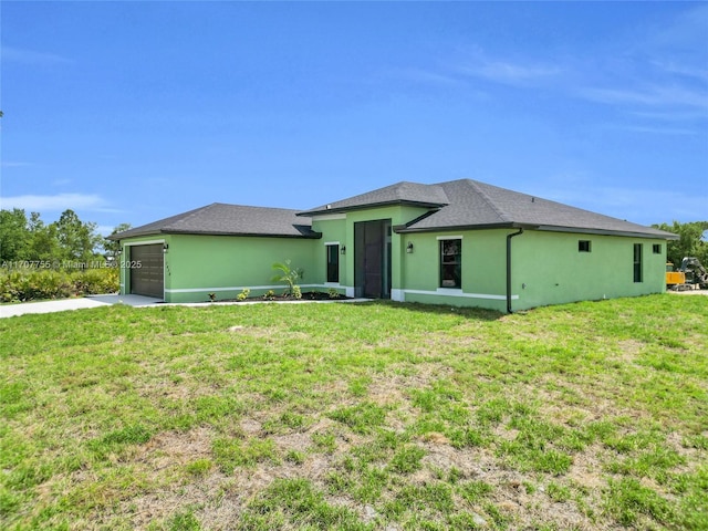 view of front of property with driveway, stucco siding, a front yard, and a garage