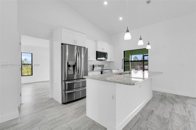 kitchen with high vaulted ceiling, white cabinets, decorative backsplash, and appliances with stainless steel finishes