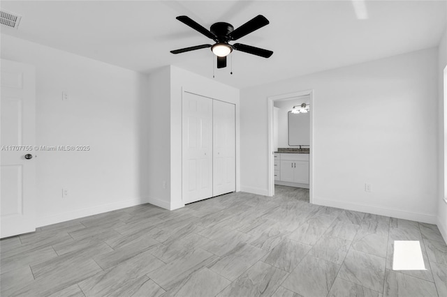 unfurnished bedroom featuring a closet, ensuite bathroom, baseboards, visible vents, and ceiling fan