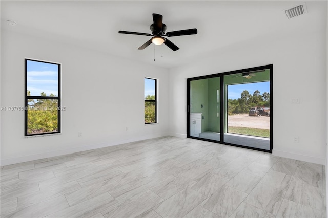 unfurnished room with a ceiling fan, baseboards, and visible vents