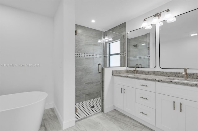 bathroom with baseboards, double vanity, a sink, and a stall shower