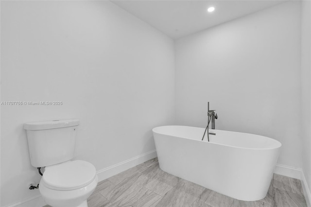 full bath with a freestanding tub, baseboards, toilet, and recessed lighting