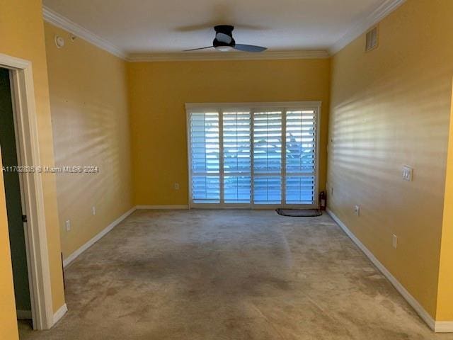 carpeted spare room featuring ceiling fan and ornamental molding