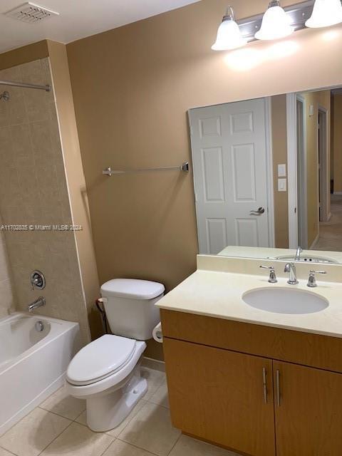 full bathroom featuring toilet, vanity, tiled shower / bath combo, and tile patterned floors