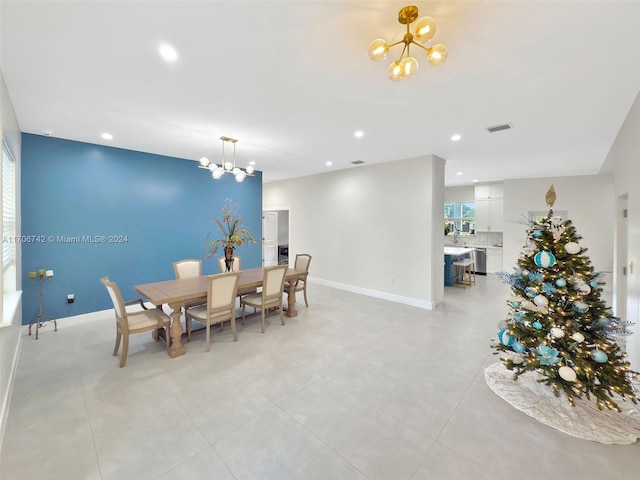 dining area with light tile patterned floors and an inviting chandelier