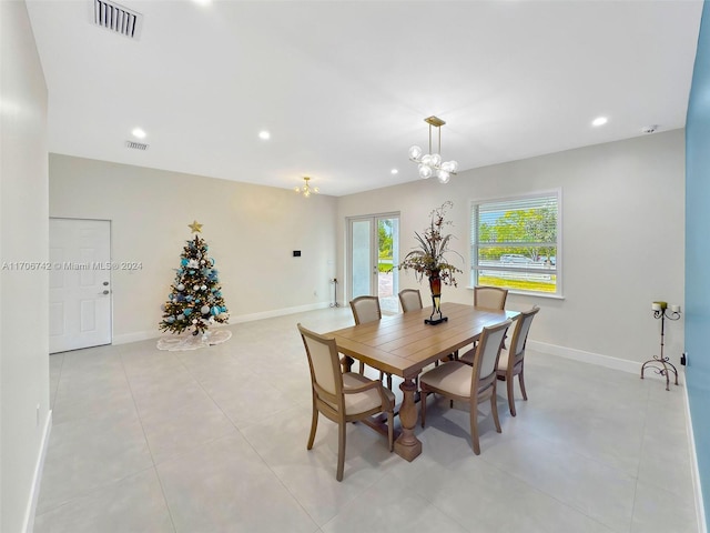 dining room with light tile patterned flooring and a chandelier