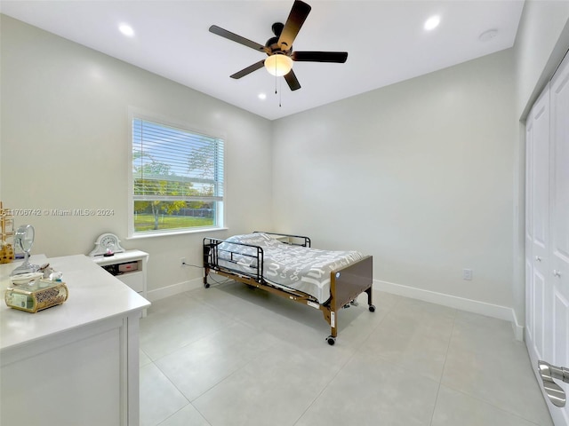 tiled bedroom with ceiling fan and a closet