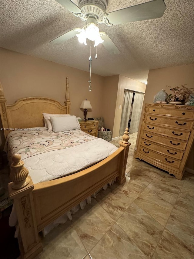 bedroom with ceiling fan and a textured ceiling