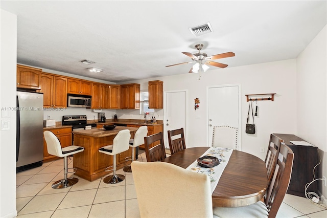 tiled dining space with ceiling fan and sink