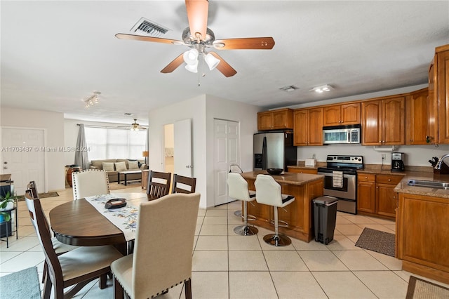 kitchen with sink, light tile patterned floors, and stainless steel appliances