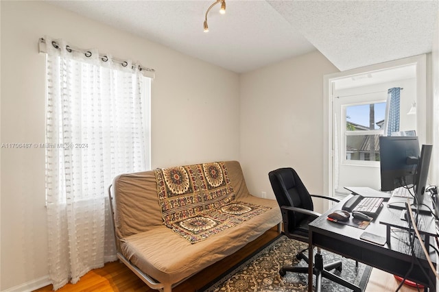 office with hardwood / wood-style flooring and a textured ceiling