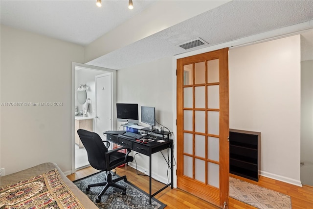 office space featuring wood-type flooring and a textured ceiling