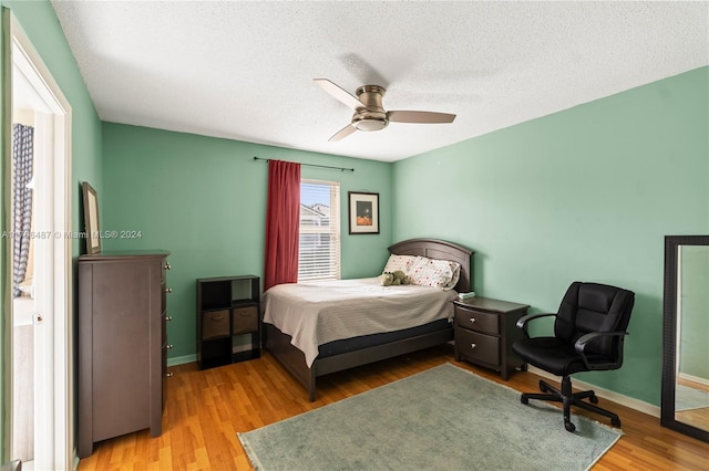 bedroom featuring hardwood / wood-style floors, a textured ceiling, and ceiling fan