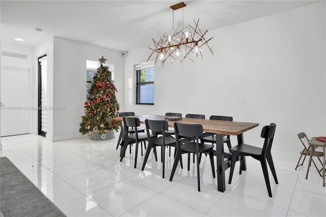 tiled dining space featuring a notable chandelier