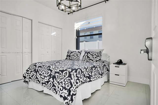 bedroom with multiple closets and an inviting chandelier