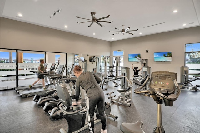 gym with ceiling fan and a towering ceiling