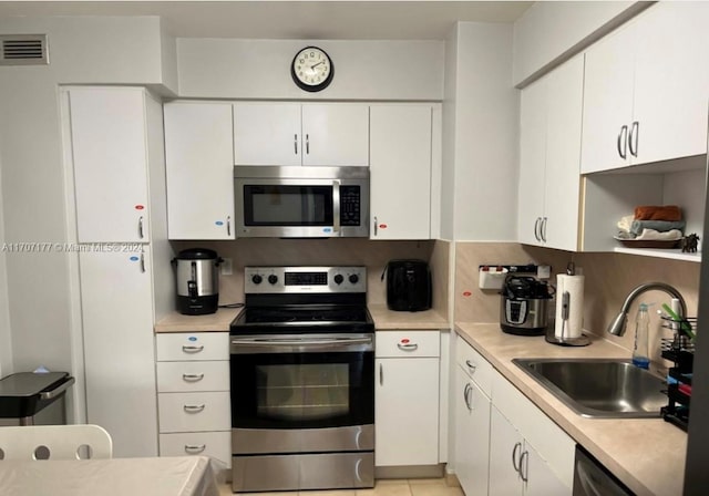 kitchen featuring white cabinets, appliances with stainless steel finishes, and sink