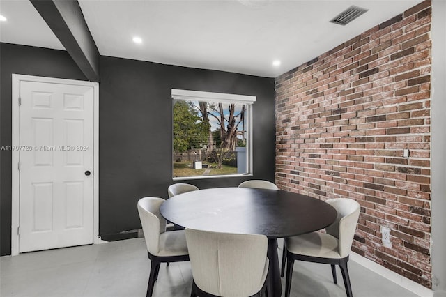 dining space featuring brick wall