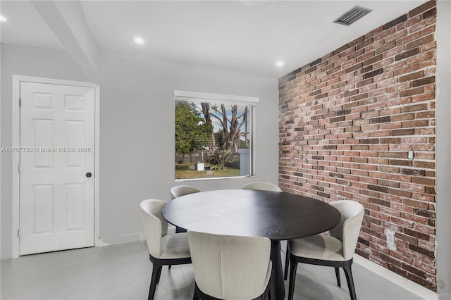 dining room featuring brick wall