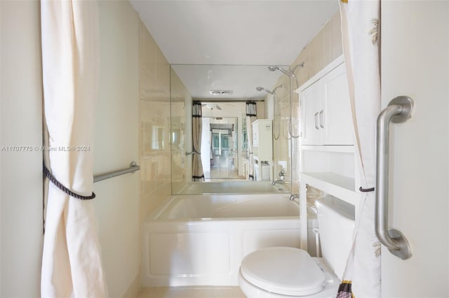 bathroom featuring toilet and tiled shower / bath