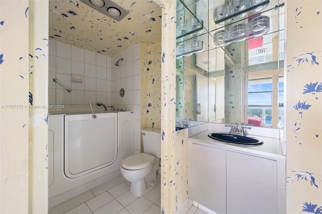 bathroom featuring tile patterned floors, a washtub, toilet, and vanity