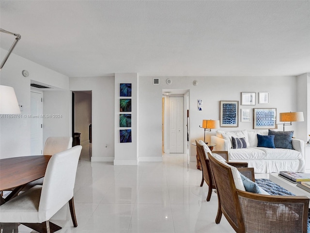 living room featuring light tile patterned flooring and a textured ceiling