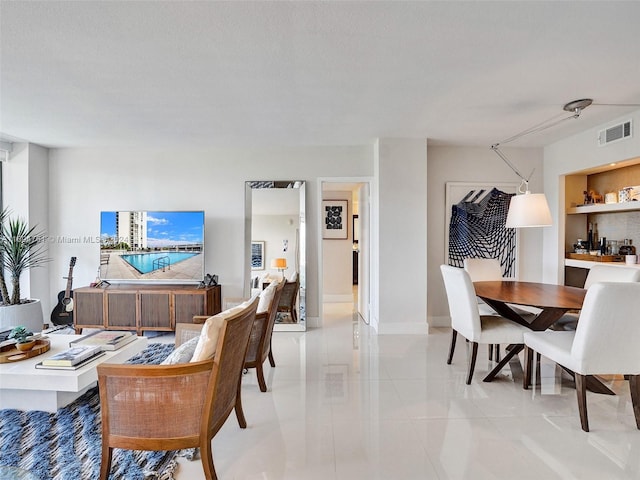 tiled dining area with a textured ceiling