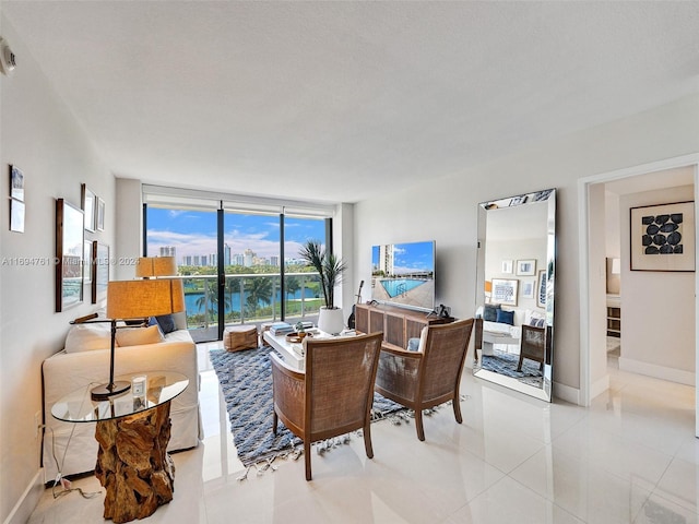 living room featuring light tile patterned floors, a textured ceiling, and a wall of windows