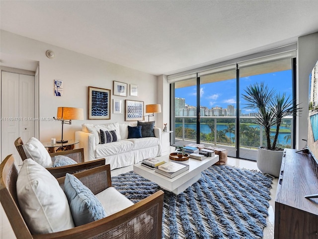 living room featuring floor to ceiling windows, hardwood / wood-style floors, a water view, and a healthy amount of sunlight