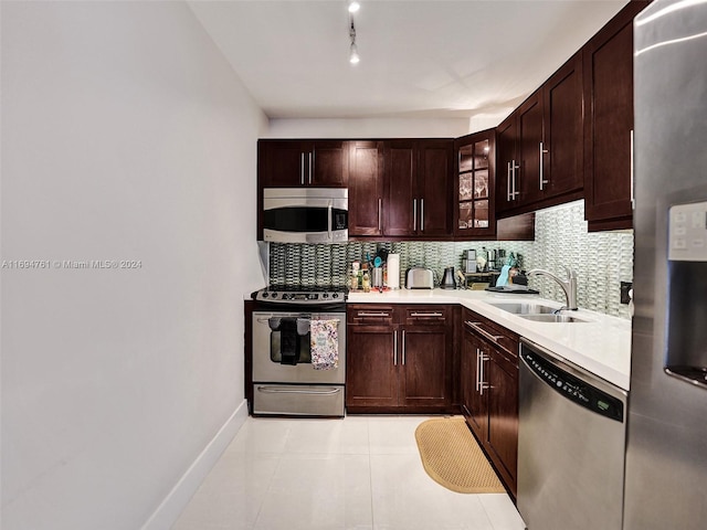 kitchen featuring tasteful backsplash, dark brown cabinets, stainless steel appliances, sink, and light tile patterned floors