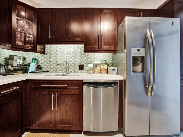 kitchen featuring decorative backsplash, sink, stainless steel appliances, and dark brown cabinets