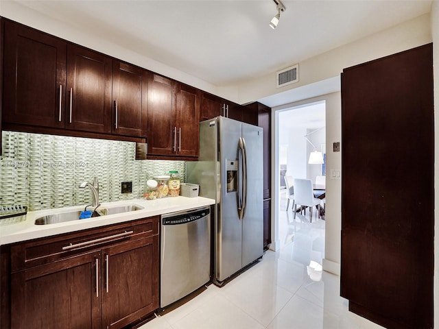 kitchen with dark brown cabinets, sink, appliances with stainless steel finishes, and tasteful backsplash