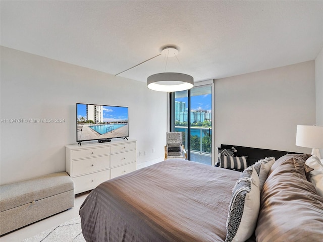 bedroom featuring a textured ceiling, access to outside, and multiple windows