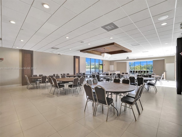 dining room featuring a tray ceiling, light tile patterned floors, and a healthy amount of sunlight