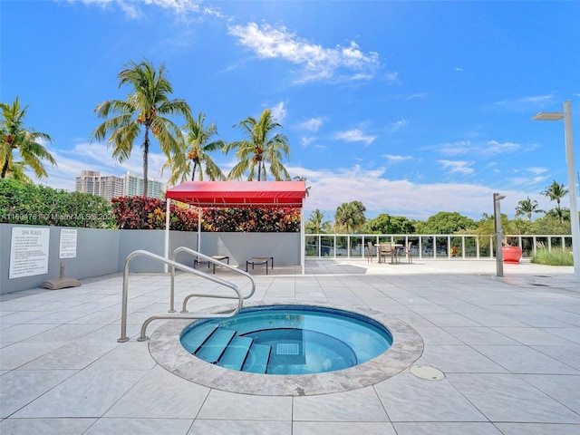 view of pool with a patio and a hot tub