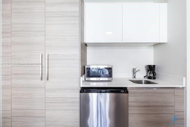 kitchen with white cabinets, sink, and appliances with stainless steel finishes