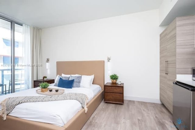 bedroom featuring access to exterior and light wood-type flooring