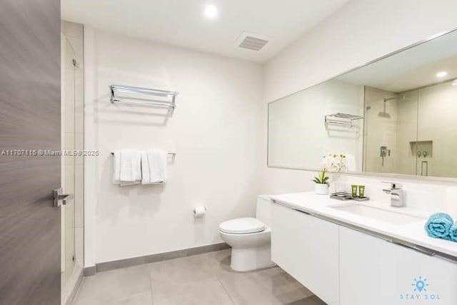 bathroom featuring tile patterned floors, a shower with door, vanity, and toilet