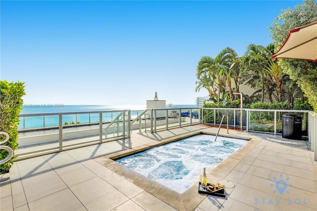 view of swimming pool with an in ground hot tub and a water view