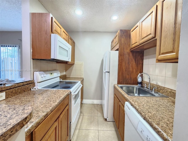 kitchen featuring sink, backsplash, a textured ceiling, white appliances, and light tile patterned flooring