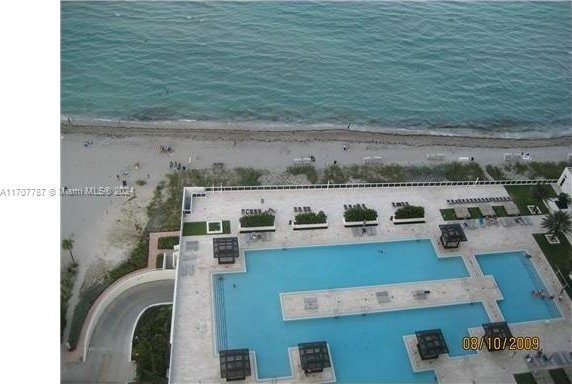 birds eye view of property with a water view and a view of the beach