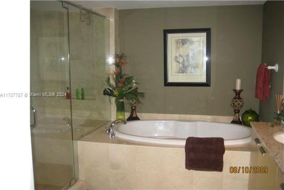 bathroom with shower with separate bathtub and vanity